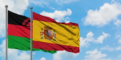 Malawi and Spain flag waving in the wind against white cloudy blue sky together. Diplomacy concept, international relations.