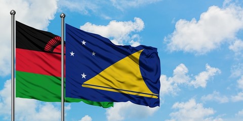 Malawi and Tokelau flag waving in the wind against white cloudy blue sky together. Diplomacy concept, international relations.
