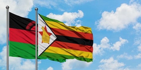 Malawi and Zimbabwe flag waving in the wind against white cloudy blue sky together. Diplomacy concept, international relations.