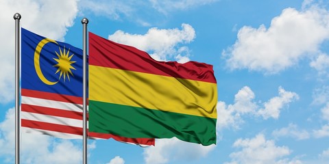 Malaysia and Bolivia flag waving in the wind against white cloudy blue sky together. Diplomacy concept, international relations.