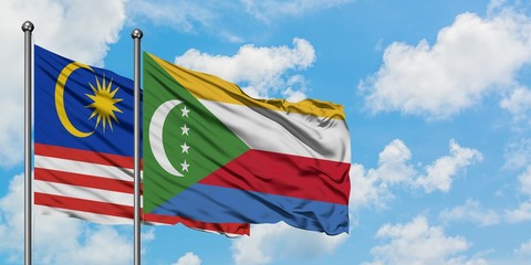 Malaysia and Comoros flag waving in the wind against white cloudy blue sky together. Diplomacy concept, international relations.