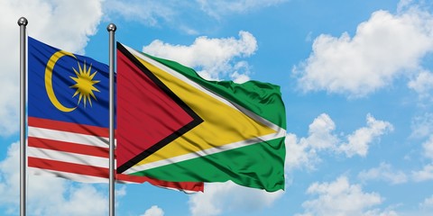 Malaysia and Guyana flag waving in the wind against white cloudy blue sky together. Diplomacy concept, international relations.