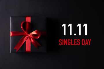 Online shopping of China, 11.11 singles day sale concept. Top view of black christmas boxes with red ribbon on black background with copy space for text 11.11 singles day sale.