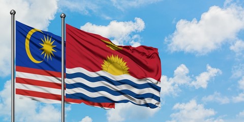 Malaysia and Kiribati flag waving in the wind against white cloudy blue sky together. Diplomacy concept, international relations.