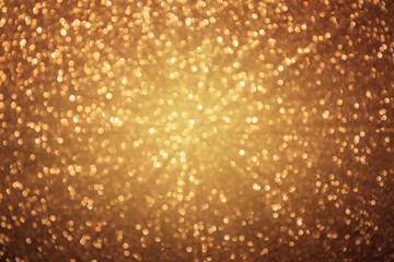 Golden glitter background. Defocused bokeh lights