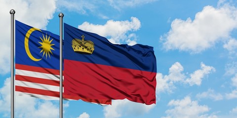 Malaysia and Liechtenstein flag waving in the wind against white cloudy blue sky together. Diplomacy concept, international relations.