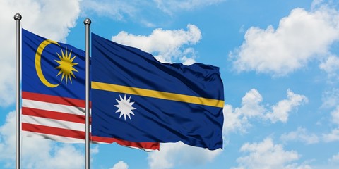 Malaysia and Nauru flag waving in the wind against white cloudy blue sky together. Diplomacy concept, international relations.
