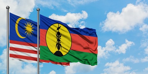 Malaysia and New Caledonia flag waving in the wind against white cloudy blue sky together. Diplomacy concept, international relations.