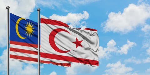 Malaysia and Northern Cyprus flag waving in the wind against white cloudy blue sky together. Diplomacy concept, international relations.