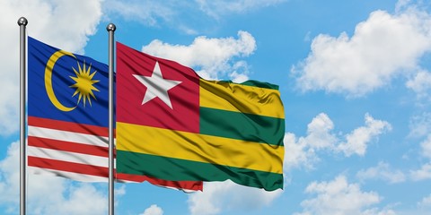 Malaysia and Togo flag waving in the wind against white cloudy blue sky together. Diplomacy concept, international relations.