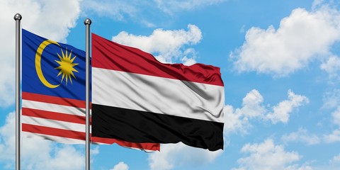 Malaysia and Yemen flag waving in the wind against white cloudy blue sky together. Diplomacy concept, international relations.