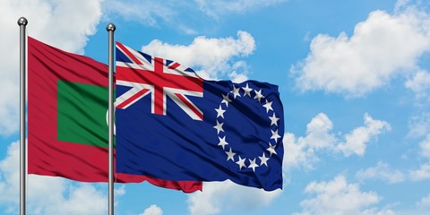 Maldives and Cook Islands flag waving in the wind against white cloudy blue sky together. Diplomacy concept, international relations.