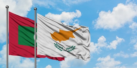 Maldives and Cyprus flag waving in the wind against white cloudy blue sky together. Diplomacy concept, international relations.