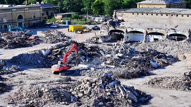 Salvaging and recycling building and construction materials. Excavator with hydraulic hammer work at landfill with concrete demolition waste.