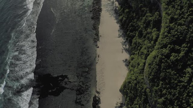 Waves breaking on the rocks Batu Balong beach Bali Island 4K Drone flight