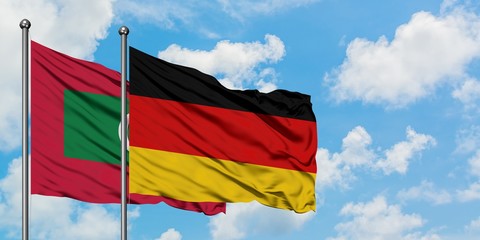 Maldives and Germany flag waving in the wind against white cloudy blue sky together. Diplomacy concept, international relations.