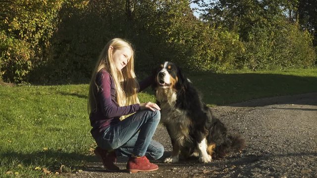 little blond girl petting a dog