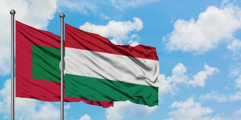 Maldives and Hungary flag waving in the wind against white cloudy blue sky together. Diplomacy concept, international relations.