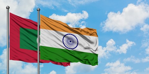 Maldives and India flag waving in the wind against white cloudy blue sky together. Diplomacy concept, international relations.