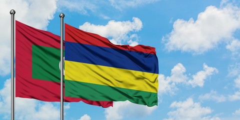 Maldives and Mauritius flag waving in the wind against white cloudy blue sky together. Diplomacy concept, international relations.