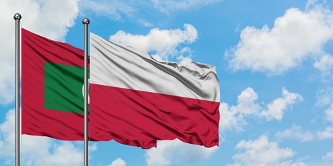 Maldives and Poland flag waving in the wind against white cloudy blue sky together. Diplomacy concept, international relations.