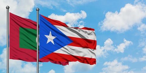 Maldives and Puerto Rico flag waving in the wind against white cloudy blue sky together. Diplomacy concept, international relations.