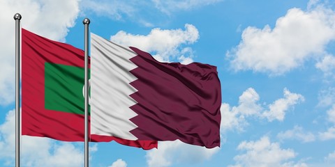 Maldives and Qatar flag waving in the wind against white cloudy blue sky together. Diplomacy concept, international relations.