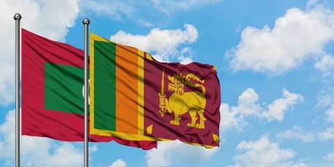 Maldives and Sri Lanka flag waving in the wind against white cloudy blue sky together. Diplomacy concept, international relations.