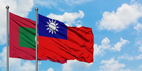 Maldives and Taiwan flag waving in the wind against white cloudy blue sky together. Diplomacy concept, international relations.