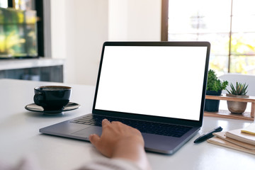 Mockup image of a hand using and touching on laptop touchpad with blank white desktop screen with...