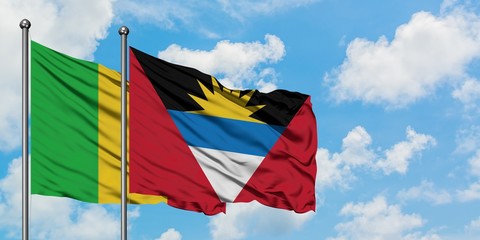 Mali and Antigua and Barbuda flag waving in the wind against white cloudy blue sky together. Diplomacy concept, international relations.