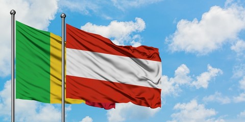 Mali and Austria flag waving in the wind against white cloudy blue sky together. Diplomacy concept, international relations.