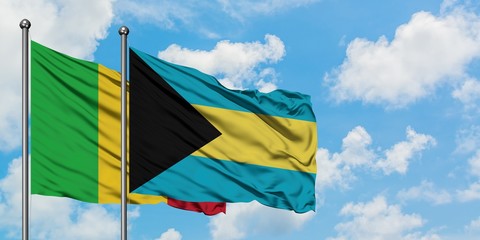 Mali and Bahamas flag waving in the wind against white cloudy blue sky together. Diplomacy concept, international relations.