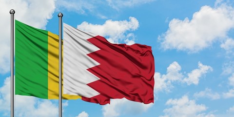 Mali and Bahrain flag waving in the wind against white cloudy blue sky together. Diplomacy concept, international relations.