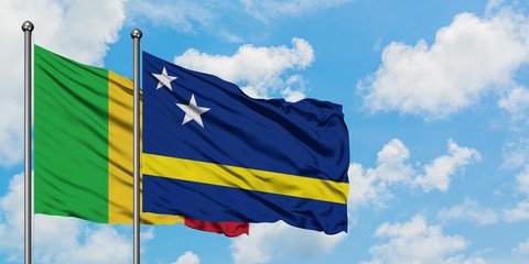 Mali and Curacao flag waving in the wind against white cloudy blue sky together. Diplomacy concept, international relations.