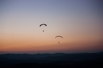 silhouette of a paraglider at sunset