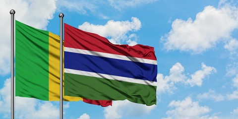 Mali and Gambia flag waving in the wind against white cloudy blue sky together. Diplomacy concept, international relations.