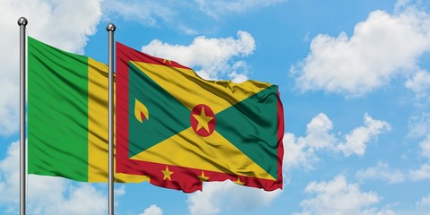 Mali and Grenada flag waving in the wind against white cloudy blue sky together. Diplomacy concept, international relations.