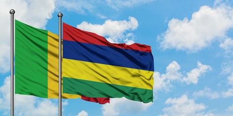Mali and Mauritius flag waving in the wind against white cloudy blue sky together. Diplomacy concept, international relations.