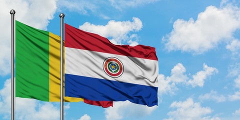 Mali and Paraguay flag waving in the wind against white cloudy blue sky together. Diplomacy concept, international relations.