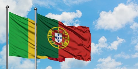 Mali and Portugal flag waving in the wind against white cloudy blue sky together. Diplomacy concept, international relations.