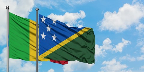 Mali and Solomon Islands flag waving in the wind against white cloudy blue sky together. Diplomacy concept, international relations.
