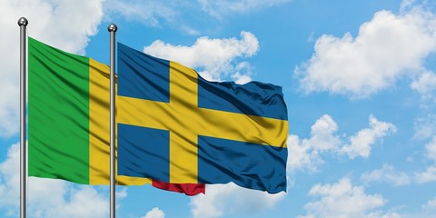 Mali and Sweden flag waving in the wind against white cloudy blue sky together. Diplomacy concept, international relations.