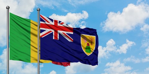Mali and Turks And Caicos Islands flag waving in the wind against white cloudy blue sky together. Diplomacy concept, international relations.