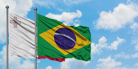 Malta and Brazil flag waving in the wind against white cloudy blue sky together. Diplomacy concept, international relations.