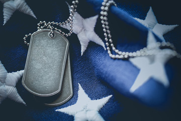 Worn USA military dog tags close up on US American flag with blank space for text - 301045124