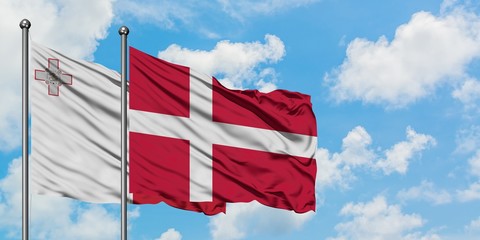 Malta and Denmark flag waving in the wind against white cloudy blue sky together. Diplomacy concept, international relations.