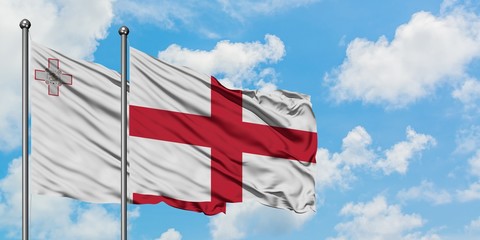 Malta and England flag waving in the wind against white cloudy blue sky together. Diplomacy concept, international relations.
