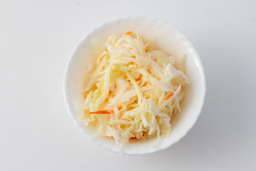 Sauerkraut in a white salad bowl. Appetizer in a bowl top view
