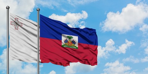 Malta and Haiti flag waving in the wind against white cloudy blue sky together. Diplomacy concept, international relations.